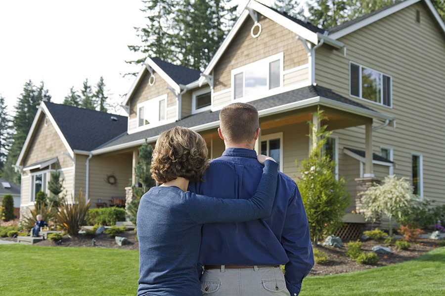 Personal Insurance - Couple Standing And Looking At Their New Two Story Home